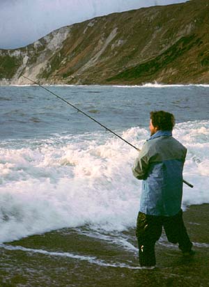 The view is looking west along the shingle beach with a good surf running.