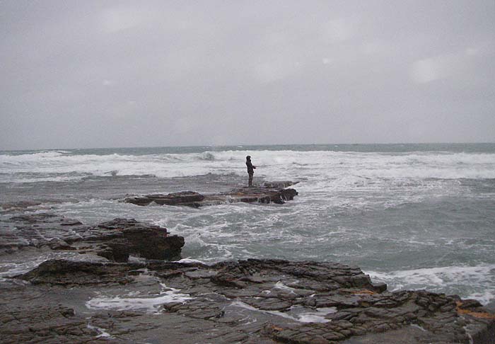 Dave Baker risks being blown into the drink to try and catch a bass.
