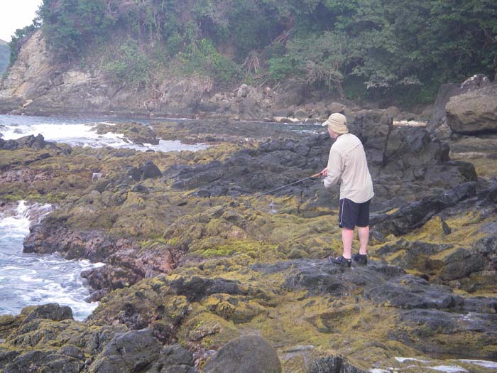 Precariously perched on slippery, algae covered-rock, Richard plugs away.