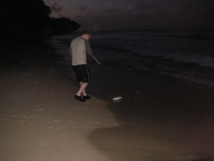 Richard's fish is beaten at last and slides ashore.