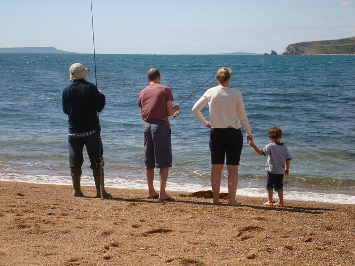 Joshua looks on while dad and grandad hold the rods.