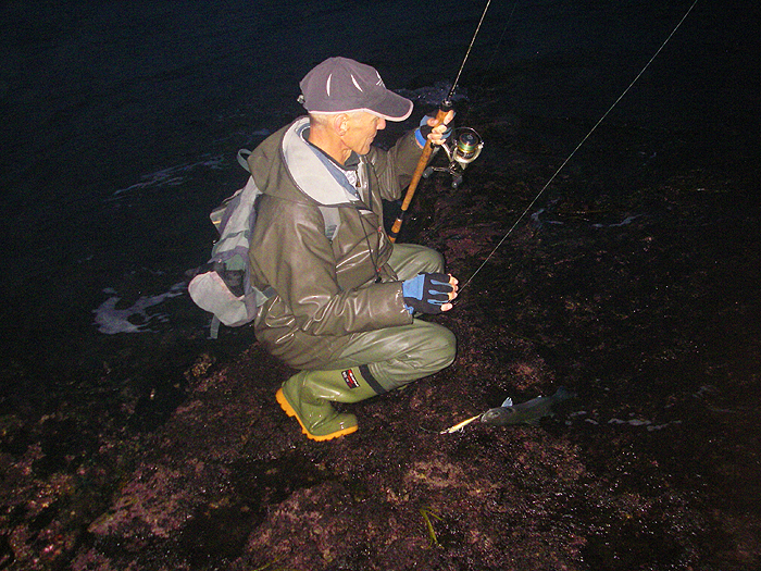 Mark squats down to unhook his bass.