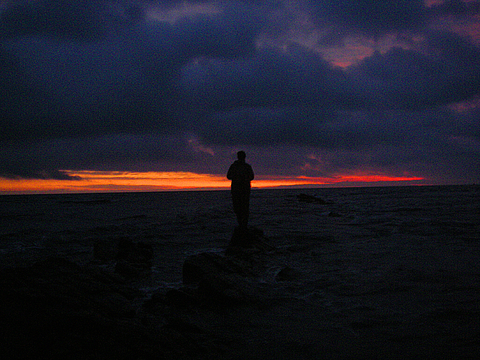 Mark casting into the race as the sun shows beneath the heavy bank of cloud.