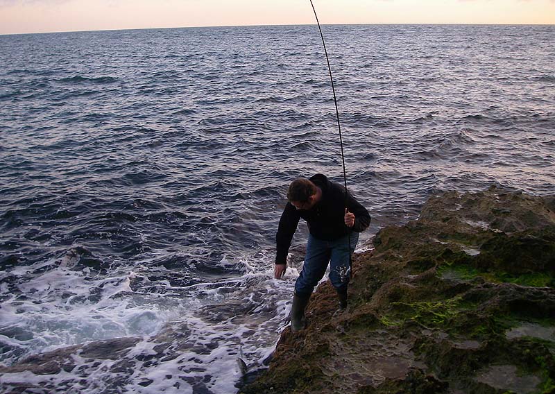 Ben hoists his fish ashore.