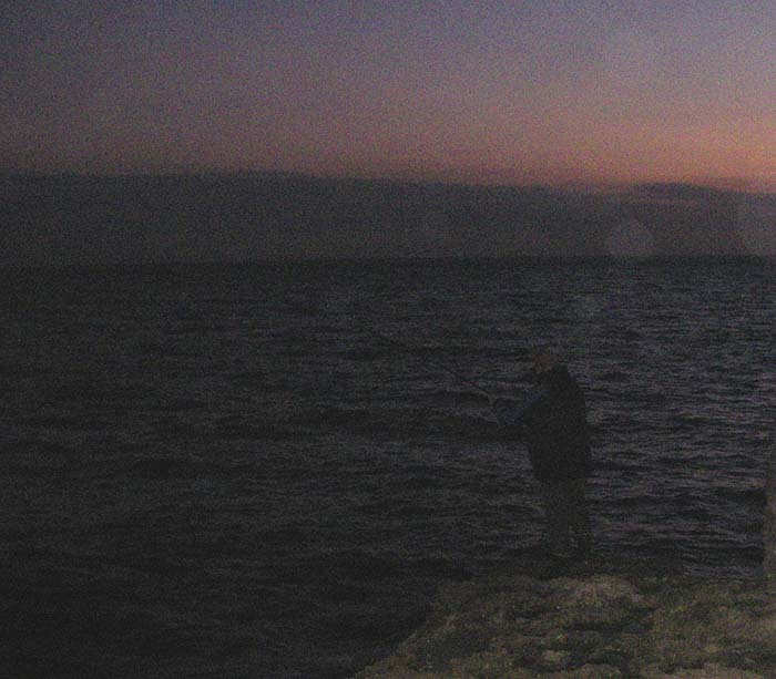 Nigel into a bass. Note that it's still pretty gloomy. This one took only a few minutes after he'd dropped the bait in.