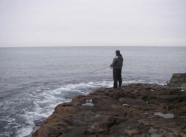 Spinning his plug in a calm November sea. Lots of bites but no hookups.