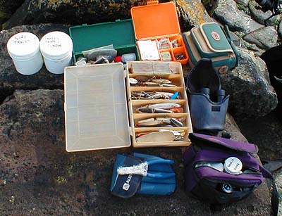 'Two white tubs with traces, lure box, orange box of bits, green box with floats etc., blue tool kit with wire cutters, camera bag, binoculars and bum bag containing small items.