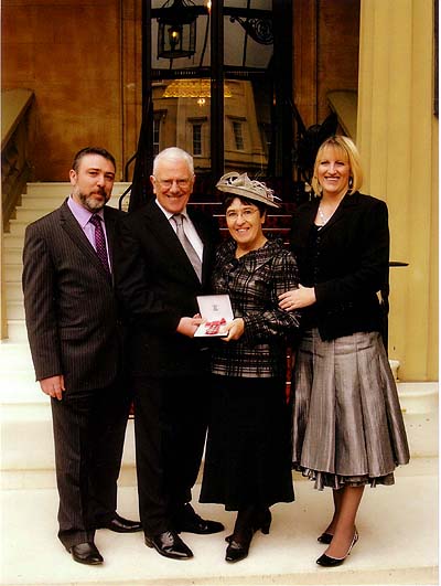 Lilian with MBE flanked by me (in suit!!!!), son Marc and his wife Linda.
